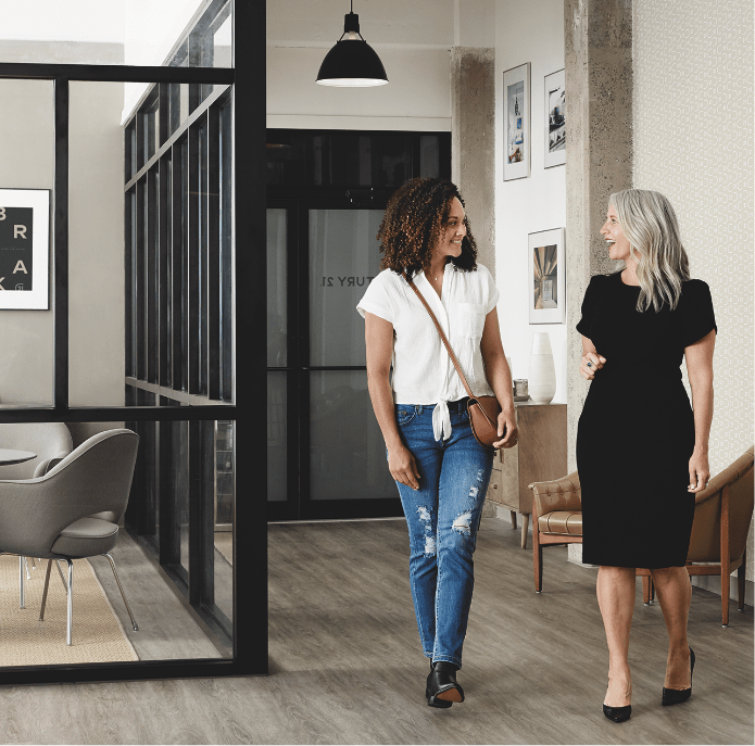 Two women walking in a Century 21 office